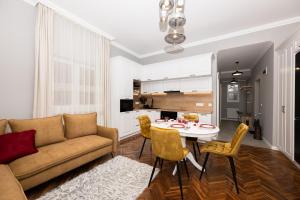 a living room with a couch and a table and chairs at Like Home in Oradea