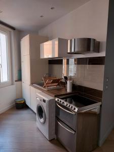 a kitchen with a stove and a washing machine at Au cosy Provençal centre historique Parking public 300m in Aix-en-Provence