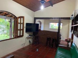 a living room with a tv and a fireplace at Casa de 5 suítes e piscina em Geribá in Búzios