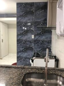 a kitchen with a sink and a marble wall at Sejam Bem Vindos ao Nucleo Bandeirante Aeroporto 102 in Núcleo Bandeirante