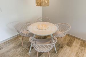 a table with four chairs and a white table and chairsktop at Luxury, Bbq & Pool In Villa Morra in Asuncion