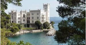 a large white building on the water in front at CASA VACANZE NONNO ASTERIO in Monfalcone