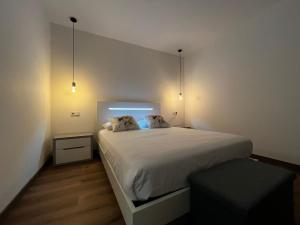 1 dormitorio con 1 cama blanca grande y 2 almohadas en Alojamento Local Monte Horeb, en Nadadouro