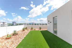 una casa blanca con césped verde en Luxury, Bbq & Pool In Villa Morra, en Asunción