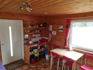 una cocina con mesa y sillas en una cabaña en Toma pirts MAZĀ, en Ikšķile