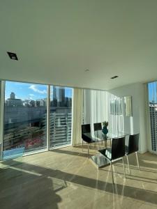 a dining room with a table and chairs and windows at Exquisite 2BD Flat w Balcony Shoreditch! in London
