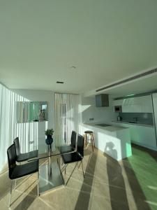 a kitchen and dining room with a glass table and chairs at Exquisite 2BD Flat w Balcony Shoreditch! in London