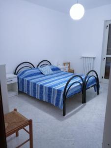 1 dormitorio con 1 cama con edredón azul en casa LULU due minuti dal mare en Ardore Marina