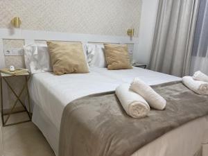 a bedroom with a white bed with towels on it at Don Carlos Marbella Beach in Marbella +63 photos