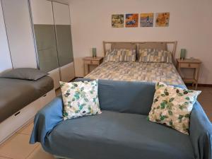 um sofá azul num quarto com uma cama em I Girasoli em Montegrotto Terme
