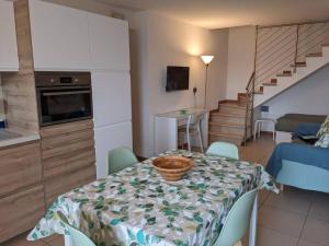 a kitchen and a dining room with a table with a basket at I Girasoli in Montegrotto Terme