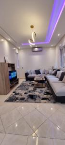 uma sala de estar com um sofá e uma televisão em Bassatine targa Marrakech à proximité de ZINAYA hammam بساتين تاركة em Marrakech