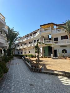 a large white building with a cobblestone street at Seven Heaven Hotel And Diving Center in Dahab