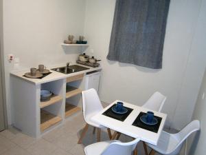 a small kitchen with a sink and a table and chairs at Harma Corfu in Sidari
