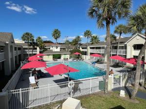 basen z czerwonymi parasolami i ośrodek w obiekcie Cozy hotel with Super location near Disney w mieście Kissimmee