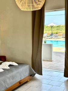 a bedroom with a bed and a view of a pool at Harma Corfu in Sidari