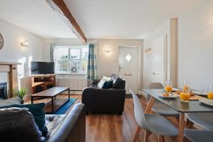 ein Wohnzimmer mit Sofa und Tisch in der Unterkunft Cross Cottage by YourStays - 2 Bedroom Cottage in Macclesfield in Macclesfield