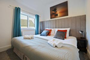 a bedroom with a large bed with towels on it at Cottage Cross by YourStays in Macclesfield