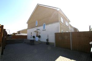 a large white house with a fence next to it at 2 Friends Close in Kent