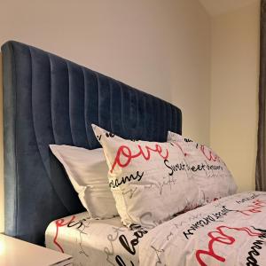a bed with a blue headboard with red writing on it at LUXURY APARTMENT in Mediterranea VARNA Complex, sea view and Infinity pool in Varna City