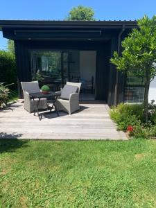 un patio con sillas y una mesa en una terraza en The Gate House, en Tauranga