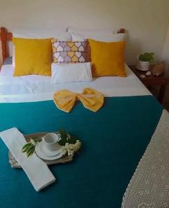 a bed with a tray with a plate and a cup anducer at Pousada Chalés Cantinho do Ronca - Paraty Mirim in Paraty