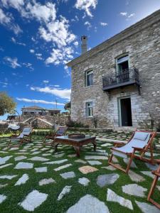a patio with chairs and a building at Nostos Country House in Tsagarada
