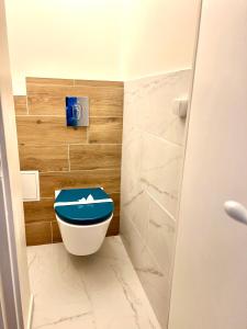 a bathroom with a toilet with a blue seat at Guest house close to Disney! in Montévrain