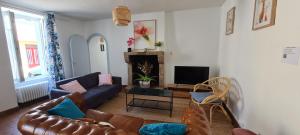 a living room with a couch and a tv at La maison d'Eglantine, 6 min du Puy du Fou, 4 chambres 10 couchages à St Malo-du-Bois, in Saint-Malo-du-Bois +51 photos