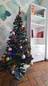 un arbre de Noël avec des ornements dans une pièce dans l'établissement La maison d'Eglantine, 6 min du Puy du Fou, 4 chambres 10 couchages à St Malo-du-Bois,, à Saint-Malo-du-Bois