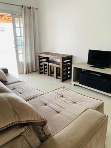 a living room with a couch and a television at Casa itapema in Itapema