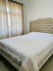 1 cama en un dormitorio con ventana grande en Casa itapema en Itapema