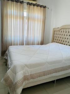 a large bed in a bedroom with a window at Casa itapema in Itapema