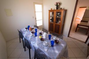 uma mesa longa com copos azuis e pratos em Casa em Baependi em Baependi