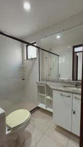 La salle de bains est pourvue de toilettes, d'un lavabo et d'un miroir. dans l'établissement Cabo Frio Elegance Apartament, à Cabo Frio