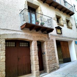un bâtiment avec deux portes de garage et un balcon dans l'établissement Casa Lidia - Antigua Posada Real, à Valderrobres