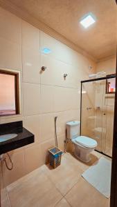 uma casa de banho com um WC, um chuveiro e um lavatório. em Canto do Rio Pousada em Vargem Bonita