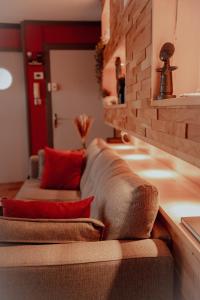 - un salon avec un canapé brun et des oreillers rouges dans l'établissement Appartement Atypique, à Soultz-Haut-Rhin