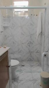 a white bathroom with a toilet and a sink at Pousada Chalés Cantinho do Ronca - Paraty Mirim in Paraty