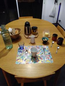 una mesa de madera con un mantel y una taza de café. en Chez Olivier et Damien en La Roche-sur-Yon