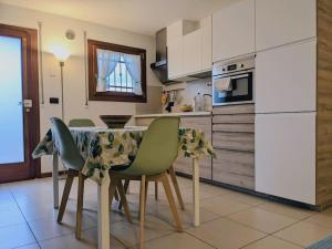 I Girasoli في مونتيجروتو تيرمي: مطبخ مع طاولة بأربعة كراسي وثلاجة