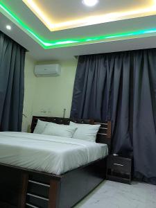 Schlafzimmer mit einem Bett mit grüner Decke in der Unterkunft JKA1-Bedroom Luxury Serviced Apartment in Lagos