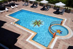 an overhead view of a swimming pool with chairs and umbrellas at Harma Corfu in Sidari