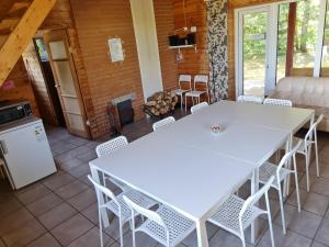 two white tables and chairs in a room with a fireplace at Toma pirts BRĪVDIENU in Ikšķile