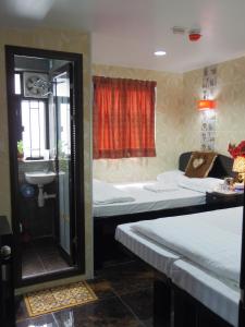 uma casa de banho com uma banheira, uma cama e um lavatório. em Mabuhay Hotel em Hong Kong