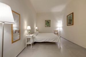 Dormitorio blanco con cama y mesa con espejo en Civico 5 Florence - Silenzioso appartamento nel cuore di Firenze San Lorenzo, en Florencia