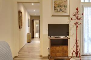 un televisor en un soporte de madera en un pasillo en Civico 5 Florence - Silenzioso appartamento nel cuore di Firenze San Lorenzo, en Florencia