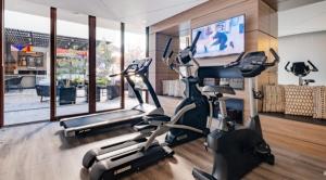a gym with two exercise bikes and a flat screen tv at Departamento central viña in Viña del Mar