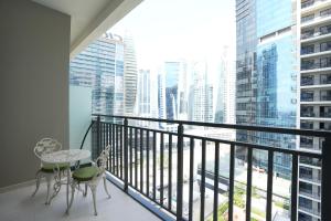 a balcony with a table and chairs and a view of a city at Cozy Flat in Business Bay in Dubai