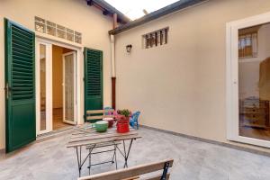 Un patio con mesa y sillas y una casa. en Civico 5 Florence - Silenzioso appartamento nel cuore di Firenze San Lorenzo, en Florencia